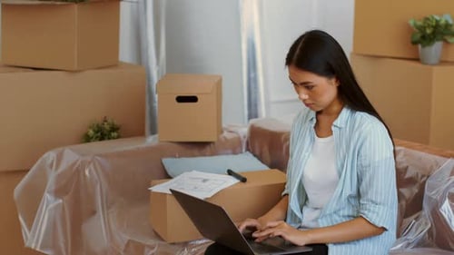 Woman Prepares for Relocation to a New Home While Organizing Packing Boxes