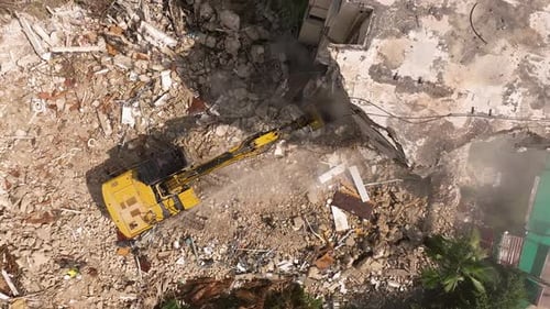 Excavator arm demolishing an old building, Aerial view