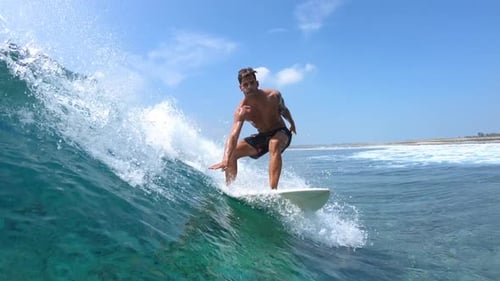 Man Surfing a Wave in Clear Tropical Ocean
