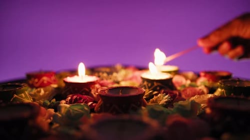 Lighting Clay Diyas with Flowers for Diwali Celebration