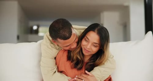 Loving Couple Embracing on Sofa at Home