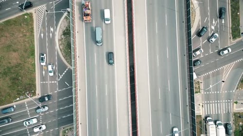 Urban veins: Drone footage over highway interlaced, reflecting non-stop flow of city traffic. Vehicu