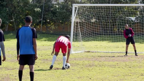 Young Adults Playing Soccer on Grassy Field