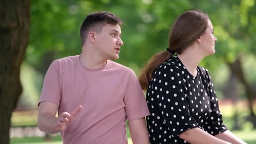 Unzufriedener junger Mann und Frau schreien, wenden sich voneinander ab und streiten sich im Freien