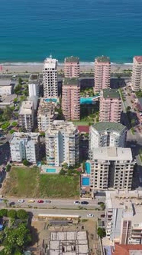 Vídeo vertical Los trabajadores colocan ladrillos y construyen paredes en una obra en construcción activa que avanza hacia