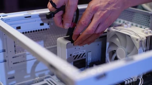 Closeup Hands of Unrecognizable Gamer Male Plugging in Graphics Card Power Cable While Assembling