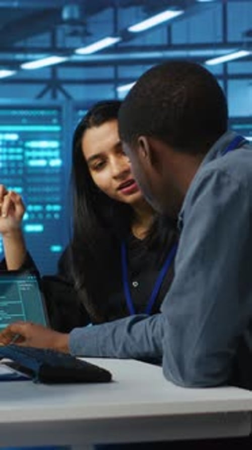 Vertical Video Diverse Team of Engineers Looking at Parameters in Data Center on Tablet