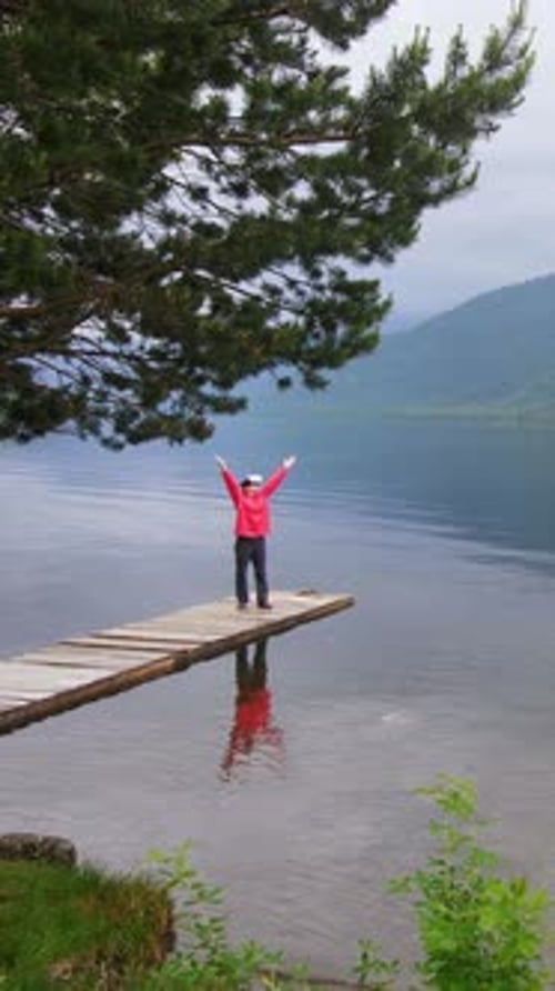 Joyful Moment on a Peaceful Lake Dock Amidst Nature's Beauty in the Early Morning