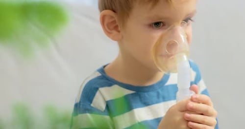 Little Boy Using Nebulizer Mask for Respiratory Treatment