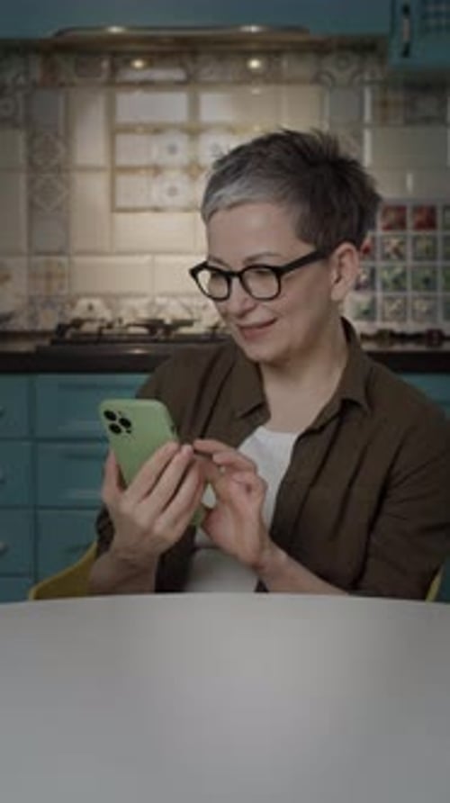 Mature Woman Showing Green Screen Cellphone at Camera Vertical Screen