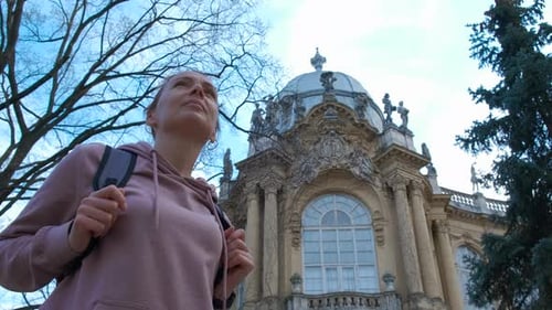 Woman Gazing at Ornate Building in Urban Setting