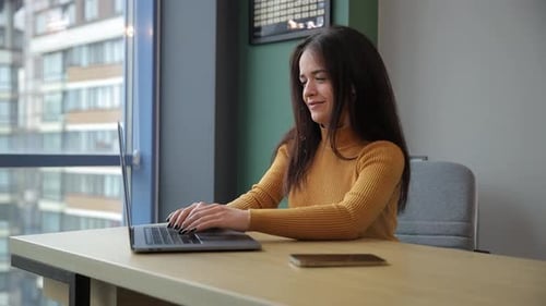 A Woman Works Diligently at Her Table Focused on Her Tasks