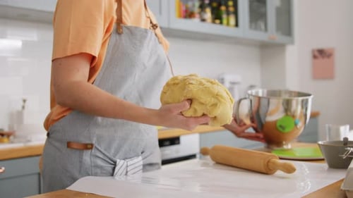 Woman prepares dough for baking in kitchen