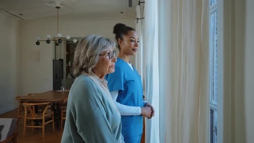 Senior Woman and Younger Woman Looking out Window