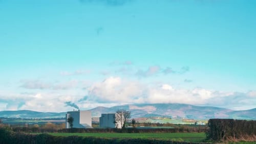 Time Lapse of the Irish countryside. A industrial factory can be seen in the foreground with A mount
