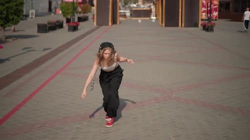 Girl Dances to Music in Urban Area