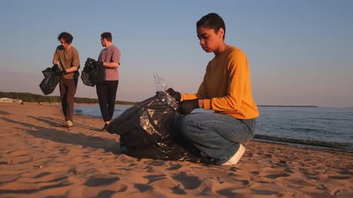 Das Aktivistenteam der Freiwilligen zum Tag der Erde sammelt Müll, reinigt den Strand und die Küstenzone, wo eine Frau
