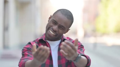 Smiling Man Invites Closer with Hand Gestures