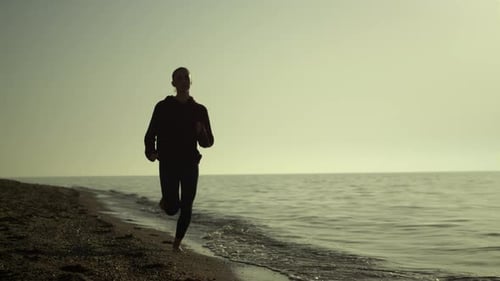 Silhouette of Athletic Woman Running Sandy Beach at Summer Sunset. Sporty Girl