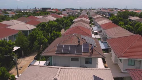 Drone view of engineer worker installed solar panels on roof of house.