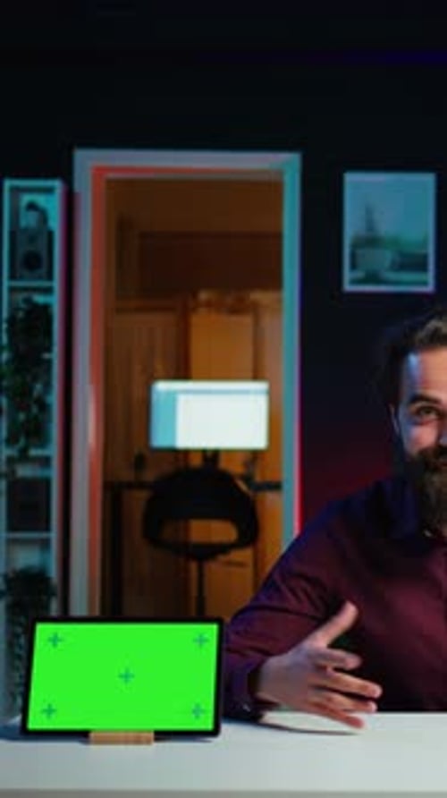 Young Adult Speaking at Desk with Tablet