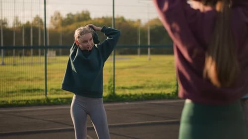 Friends Stretching Together on Sunny Day