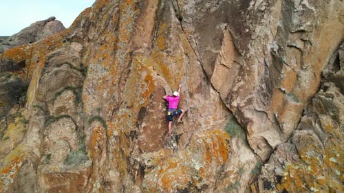 Man Athlete Climbing on the High Rock