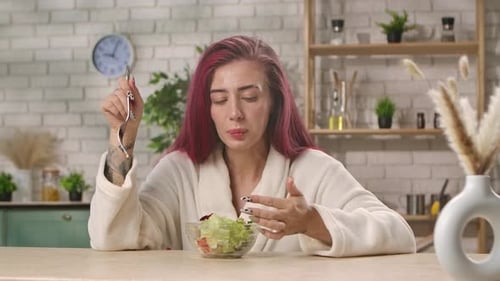 Woman in Bathrobe Eating Healthy Salad in Kitchen