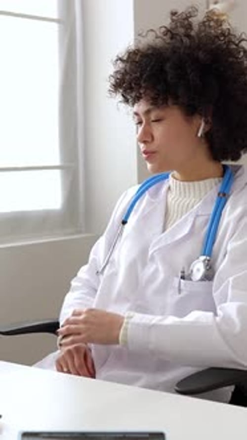 Young Woman Doctor in Lab Coat Consults Online