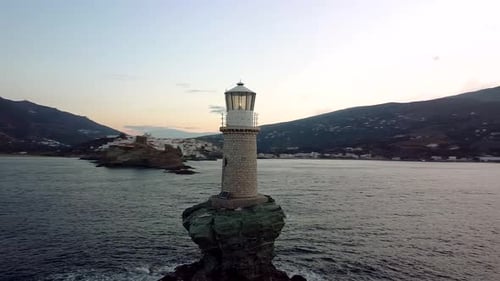 Vista en órbita del faro de Andros Tourlitis al atardecer, Grecia
