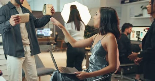 Woman Working on Laptop While Getting Hair Styled