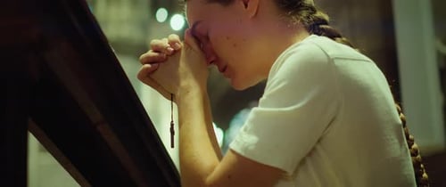 Woman talking to God in prayer. Adult girl knelt in church. Sincerely believing person, forgiveness