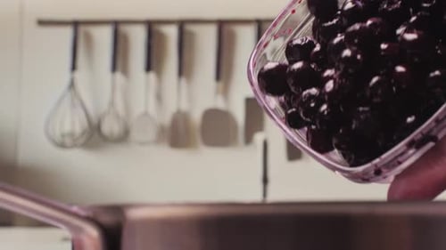 Blueberries being poured into a pot