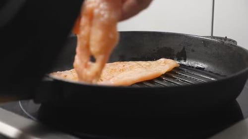 Male Hand of Cook Putting Chicken Fillet on Grill Pan at Cuisine Restaurant