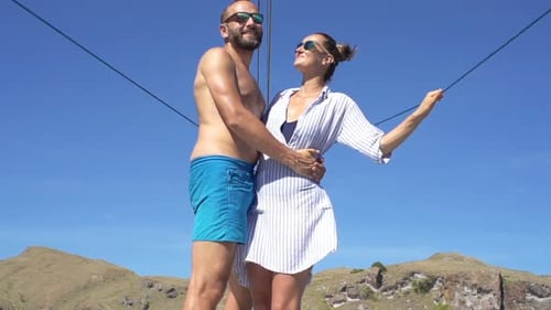 Happy young couple embracing on a sailing yacht in exotic ocean super slow motion