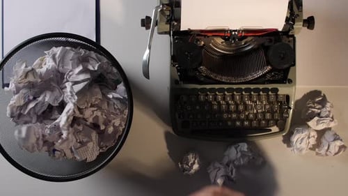 Writer's Block: Crumpling Paper Next to a Vintage Typewriter