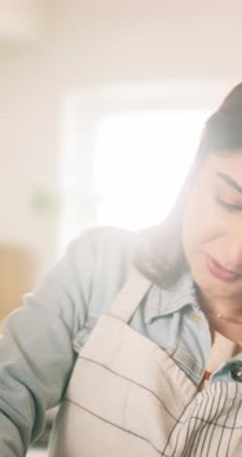 Woman Prepares Food in Brightly Lit Kitchen