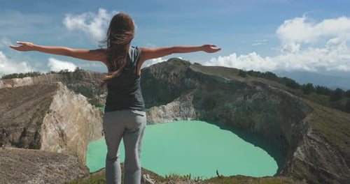 Woman Standing on Mountain Peak By Volcanic Lake