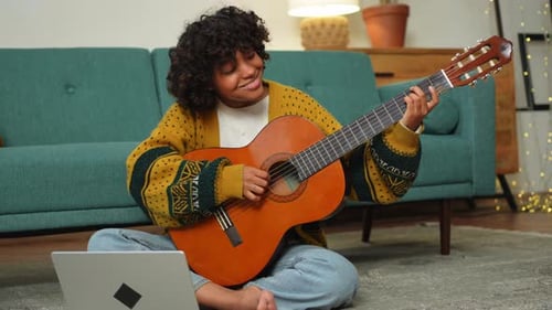 Young Adult Plays Guitar at Home