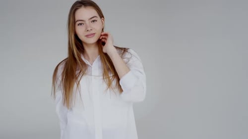Confident Young Woman in White Shirt Posing with a Smile