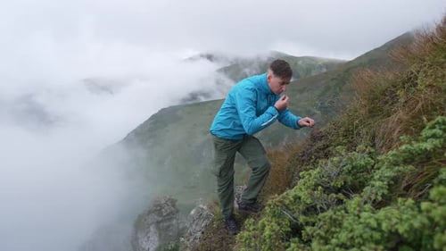 Man Samples Berries while Hiking on Mountain Ridge