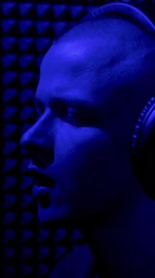 Man Singing In Recording Studio with Microphone HDR Side View of a Young Male Singer Recording a