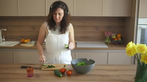 Woman with Headphones Dances While Preparing Food