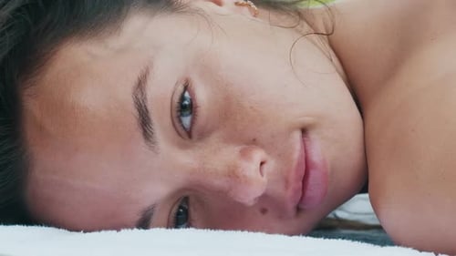 Massagem nos trópicos. Mulher olha para a câmera durante a massagem. Massagista faz massagem