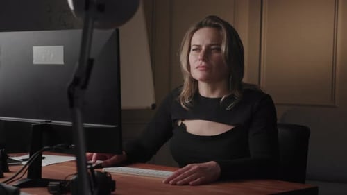 A Professional Businesswoman is Focused on Work Sitting at Her Desk in an Office Environment