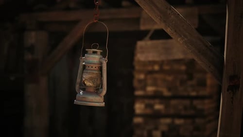 Vintage-Öllaterne, die in den Abendstunden in einem rustikalen Holzschuppen hängt