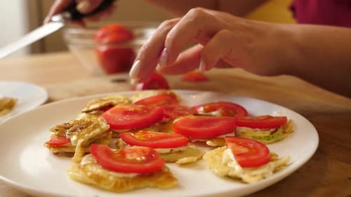 Woman Preparing Savory Pancakes with Tomatoes in Kitchen