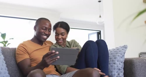 Loving Couple Using Tablet on Couch Together