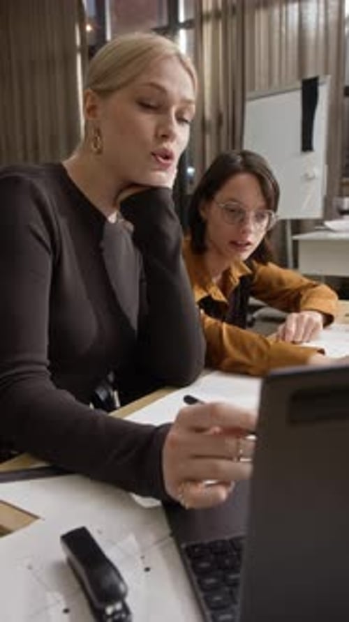 Female Architects Working with Laptop and Blueprints in Office