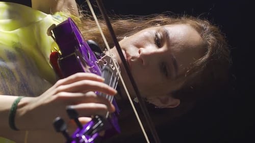 Vertical Video of Female violinist playing the violin in the opera or dark music hall. Classical Mus